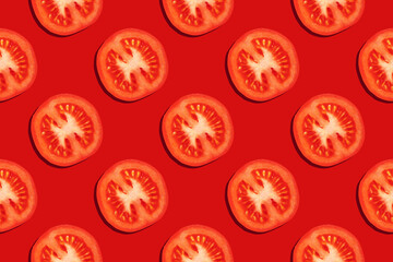 Seamless pattern from slices of ripe tomatoes on a red background