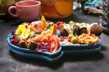 Falafel with vegetables, a colorful vegetarian dish. A healthy vegan diet.
Tasty colorful healthy dish served on a background of green plants. Suggestion to serve the dish. Culinary photography.