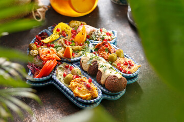Falafel with vegetables, a colorful vegetarian dish. A healthy vegan diet.
Tasty colorful healthy dish served on a background of green plants. Suggestion to serve the dish. Culinary photography.