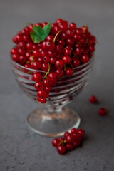Currants in a bowl on a black background. Red berry. Vitamin berries. Copy space