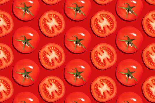 Seamless pattern of whole with green leaves and cut tomatoes on a red background
