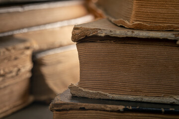 Stacks of old multi-format books with scuffs. Low depth of field photography