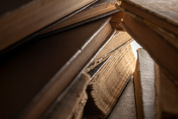 Stacks of old multi-format books with scuffs. Low depth of field photography
