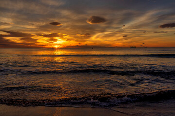 Obraz na płótnie Canvas A beautiful sunrise from the shore of the beach
