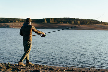 Fisherman with rod fishing on the lake