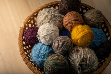 Knitting supplies close-up. Balls of knitting wool in a round wicker basket.