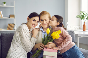 Portrait of three generations of women, mom, grandma and granddaughter celebrating event. Girl with...