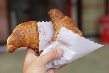Man holding two traditional Italian or French fresh crusty croissants, food concept