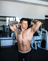 focused bodybuilder does exercises in the gym.