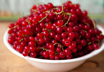 Currants in a bowl on a weeden background. Red berry. Vitamin berries. Copy space