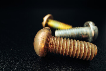 Iron screw bolts on black background close up