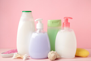 Collection of various beauty hygiene containers on pink background. Shower gel