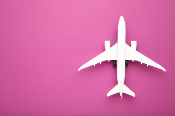 Model airplane on pink color background with copy space.