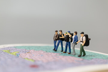 Miniature people Backpacker walking on map Travel and Adventure concepts
