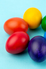 Multicolored eggs at studio on blue background