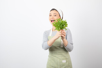 Portrait of a pretty cute woman holding beam of fresh parsley