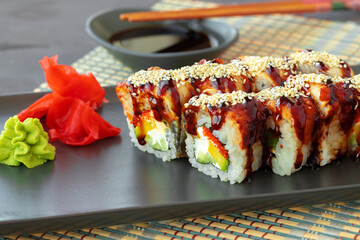 Dragon sushi roll with eel on black ceramic plate