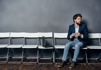 Business man in a suit sits on a chair in front of a laptop work lifestyle