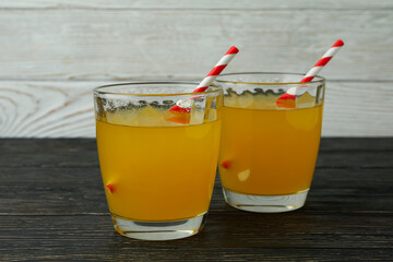 Glasses of orange soda on wooden background