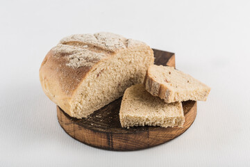 Bread cut into pieces lies on a wooden board on a white background, isolated.