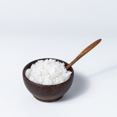 Sea salt in wooden bowl on white background