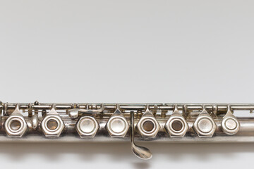 Silvery musical instrument with keys on a white background with soft shadow