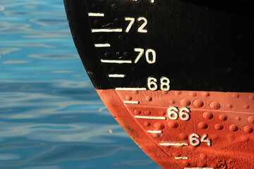 Red ship hull with waterline and draft scale measure