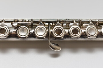 Silvery musical instrument with keys on a white background with soft shadow