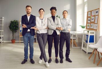 Fototapeta premium Teamwork, collaboration, partnership concept. Group of smiling mixed race business partners office workers standing and holding crossed hands of each other meaning support unity