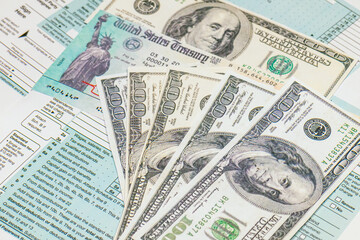 Stimulus economic tax return check and and 1040 Form with dollars.