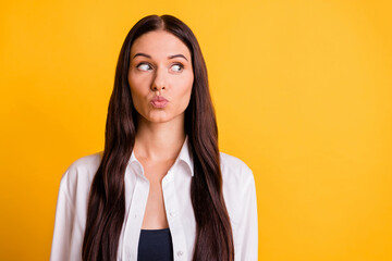 Photo of charming pretty young lady send air kiss look stand empty space isolated on yellow color background