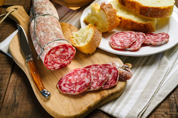 Salami sliced on wooden cutting board