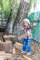 the child cuts wood with an axe and throws it into a pile