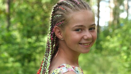 Teenage girl posing with multi-colored dreadlocks.