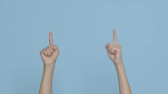 Close up cropped man hand showing thumb up gesture sign isolated on blue background in studio. Place for text image promotional content.