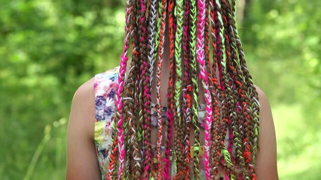 Teenage girl posing with multi-colored dreadlocks.