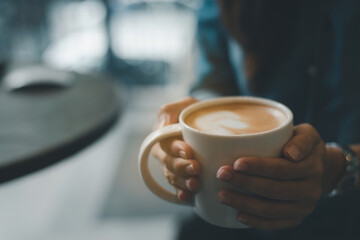 The girl hands holding hot cup of coffee. Hot coffee in the hands close-up