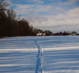 snowy winter rural landscape on a sunny frosty morning.snow with ski track