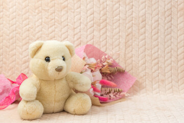 White teddy bear with bouquet flowers