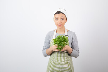 Portrait of a pretty cute woman holding beam of fresh parsley