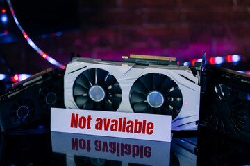 Graphics cards of different sizes and configurations on black table under neon light. Part of computer for gaming and cryptocurrency mining