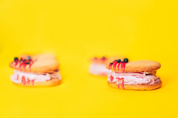 Heart-shaped cakes are positioned in the middle of yellow background. Homemade cakes for holiday, party and gift to your loved one