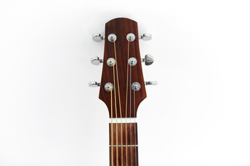music and musical instruments concept - close up of acoustic guitar head with pegs on white...