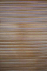 Vinyl siding with wood texture imitation, dark brown color, plastic wall, door of a garage, abstract background with horizontal tiles