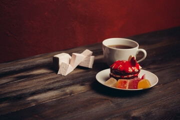 cup of tea red cake on a saucer sweets dessert wooden background