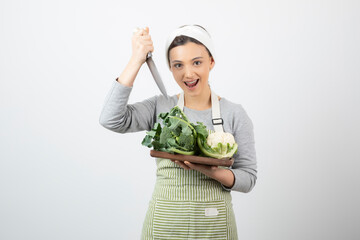 Picture of a smiling attractive woman holding a knife with a wooden plate