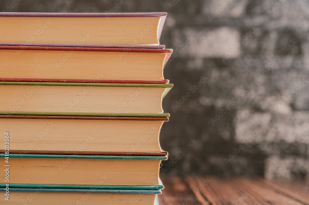 Canvas Prints Stack of books in the colored cover lay on the wood table  with dark backround. Education learning concept