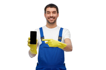 Fototapeta na wymiar profession, cleaning service and people concept - happy smiling male worker or cleaner in overall and gloves showing smartphone over white background