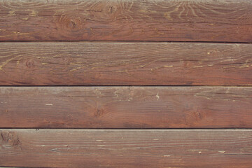 The red-brown surface of an old wooden wall made of horizontal semicircular planks. Background for design. Place for text
