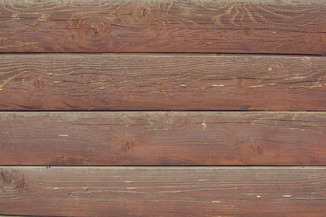 Fototapeta premium The red-brown surface of an old wooden wall made of horizontal semicircular planks. Background for design. Place for text